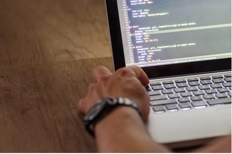 Person programmiert auf einem Laptop
