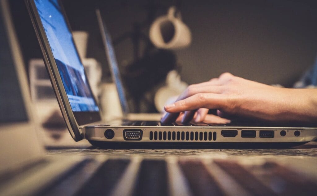 Hände tippen auf Laptop-Tastatur